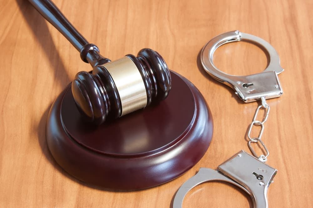 Judicial hammer and handcuffs on a wooden table