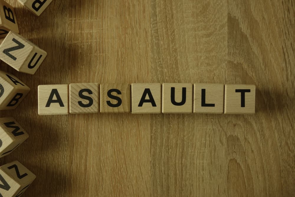 Assault word from wooden blocks on desk