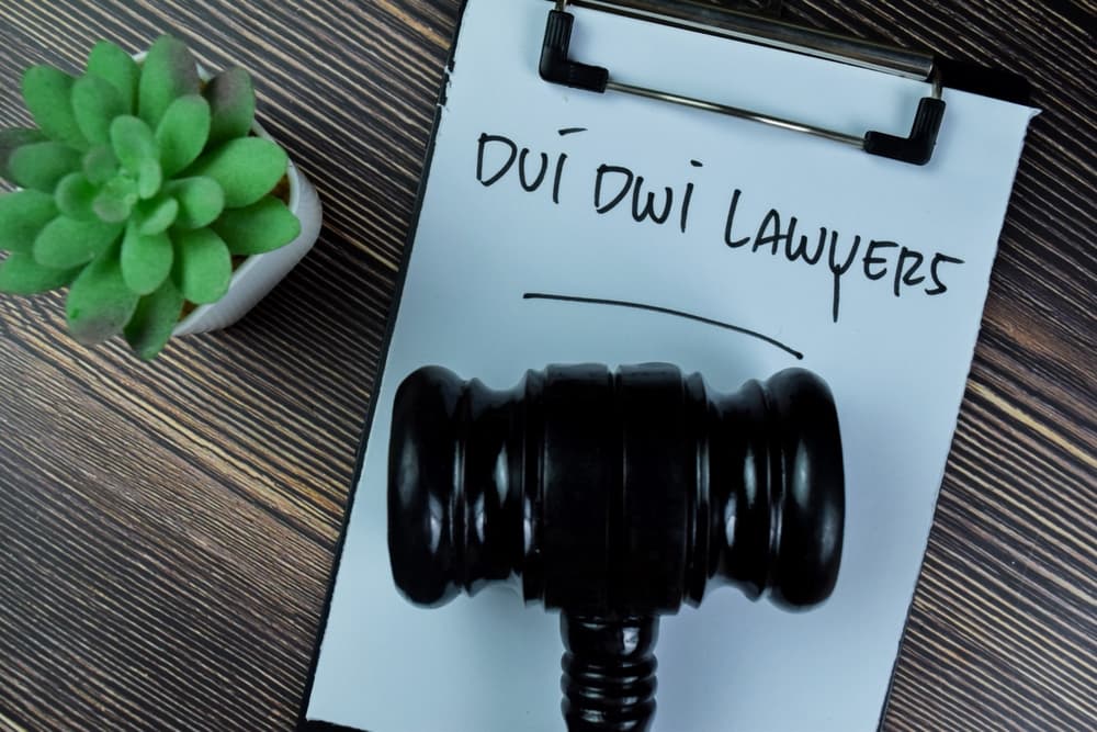 Concept of Dui Dwi Lawyers write on paperwork with gavel isolated on Wooden Table.